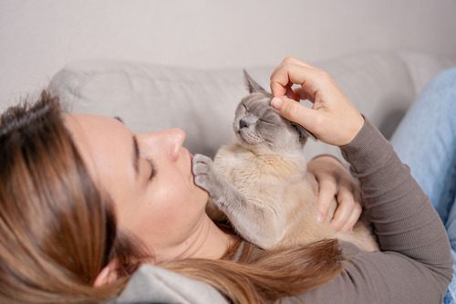 female-owner-cuddling-cat-on-the-couch